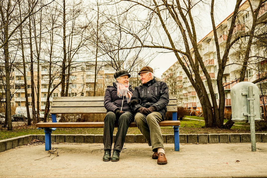 elderly couple on bench talking